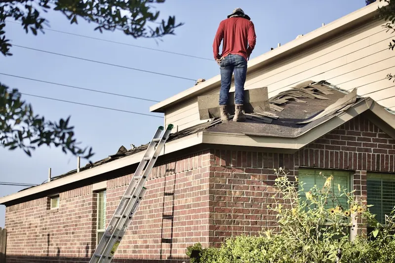 Professional roofer working on a residential roof in Delos